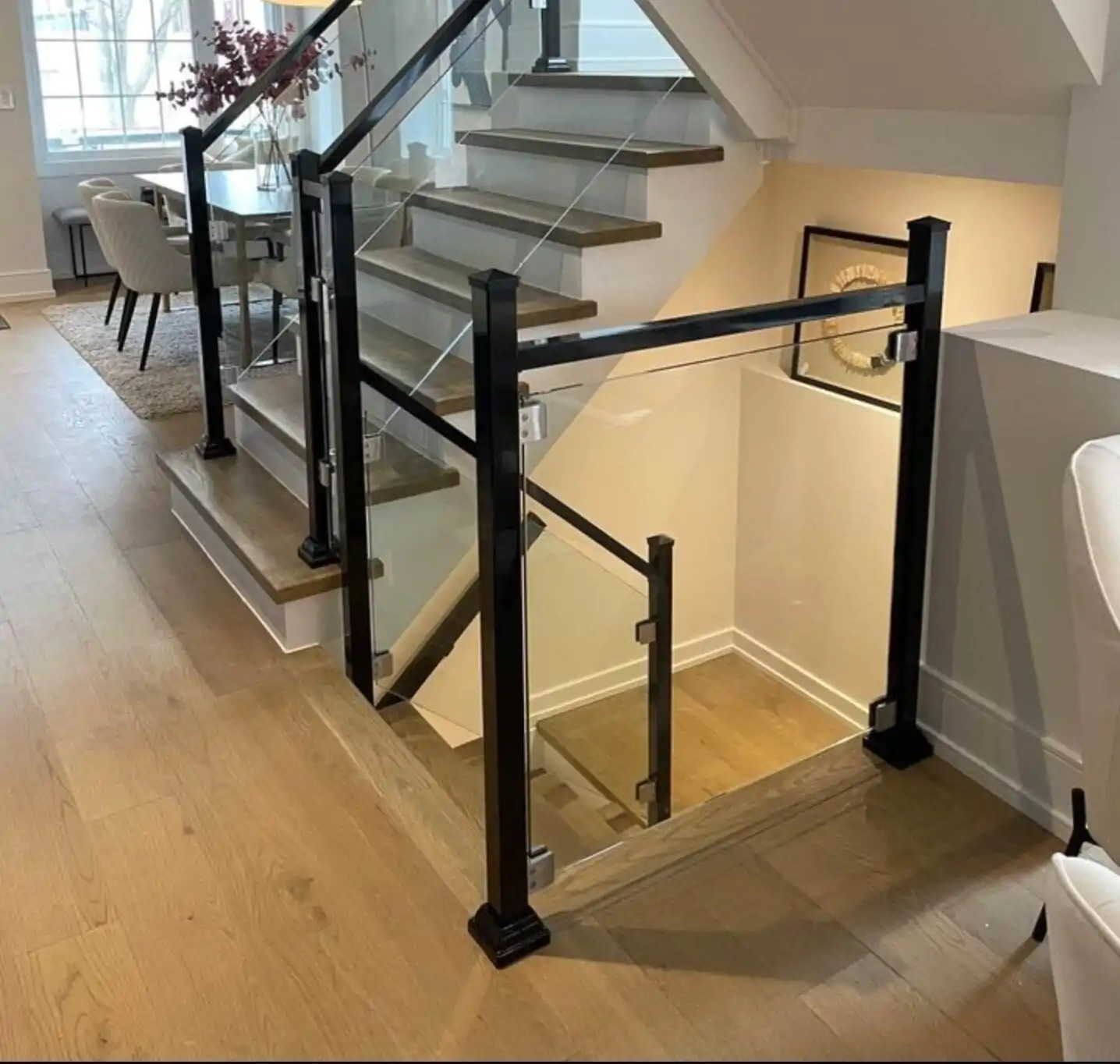 Custom modern interior aluminum railing ontario project featuring a sleek black staircase frame with integrated heavy tempered safety glass panels inside a luxury residential foyer