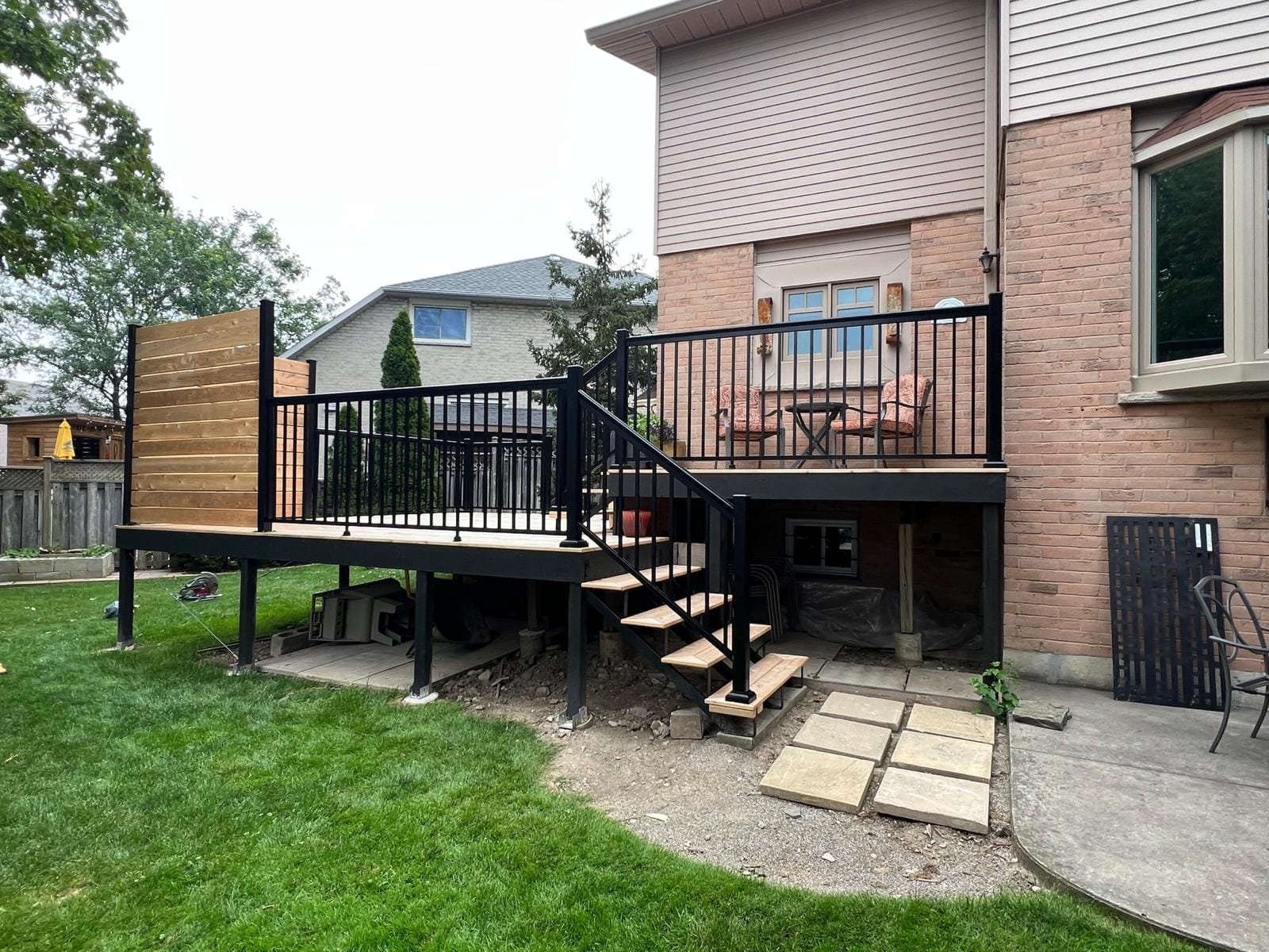 Sleek black aluminum deck railing system on a modern residential backyard patio setup